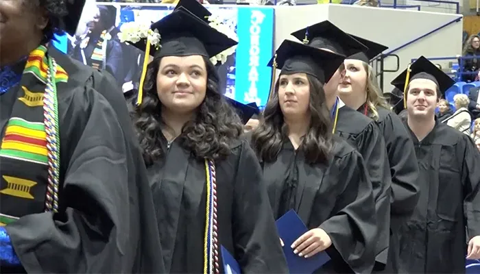 a student walks at graduation